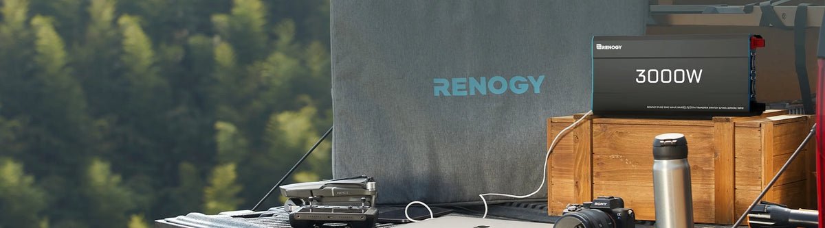 „Renogy“ 12 V grynos sinusinės bangos inverteris su UPS funkcija – stovykloje ant medinės dėžės šalia fotoaparato ir termoso